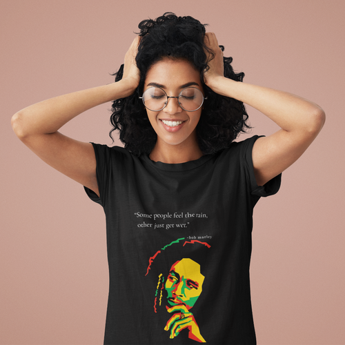 Woman wearing a black t-shirt with a colorful graphic and text, against a beige background